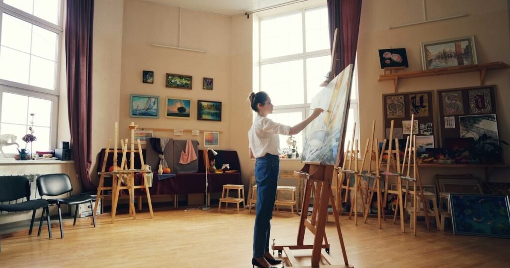 Arte-educadora pintando em ateliê, representando a profissão de arte-educador