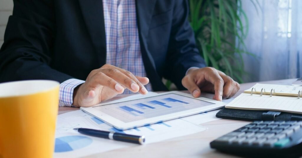 Profissional analisa relatórios financeiros em tablet, simbolizando o trabalho de contabilidade pública e controle da Lei de Responsabilidade Fiscal