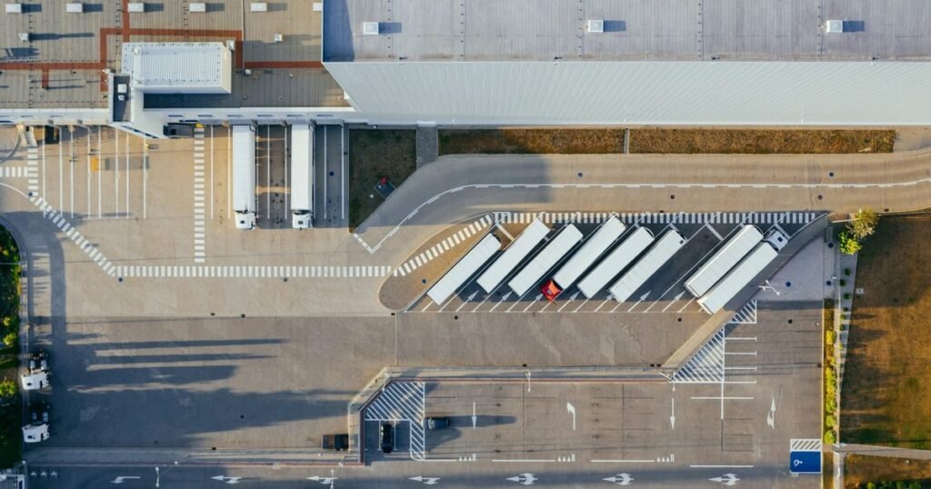 Vista aérea de centro de distribuição com carretas encostadas nas docas de carga ao entardecer