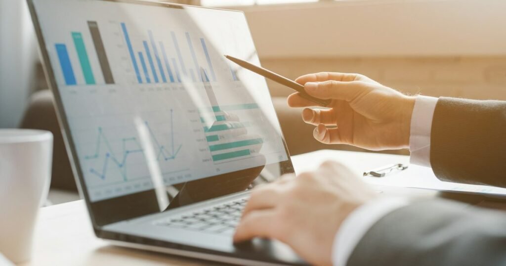 Gestor de marketing digital analisando gráficos de campanha em um laptop