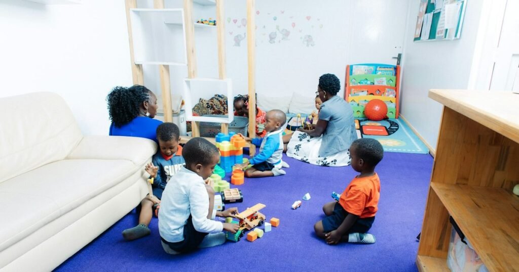 Educadora e criancas brincando com blocos de montar em sala de estimulacao psicomotora