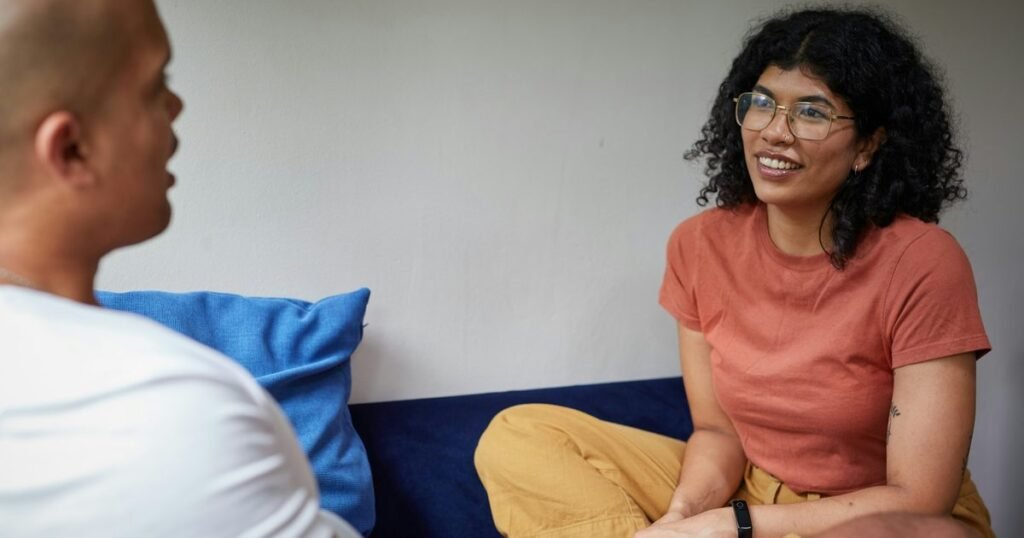Casal em conversa aberta e acolhedora, representando a terapia de casal e familia