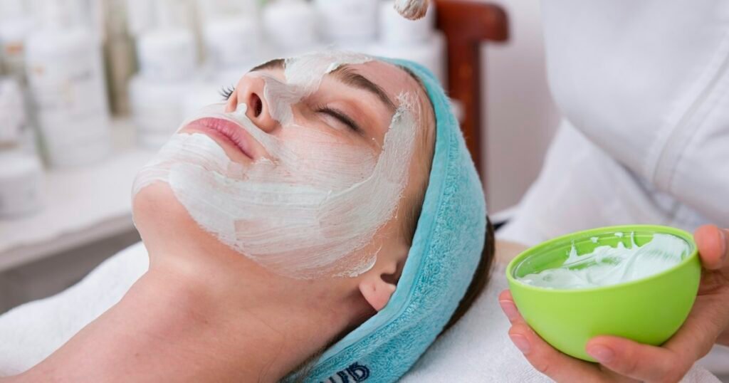 Profissional de estética aplicando máscara facial em cliente, representando a pós em Estética Facial e Corporal Avançada da UFEM